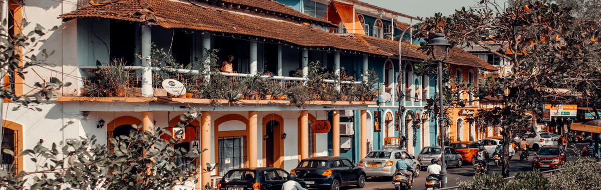 Vibrant street view in Panaji, India showcasing colorful colonial architecture and bustling traffic.