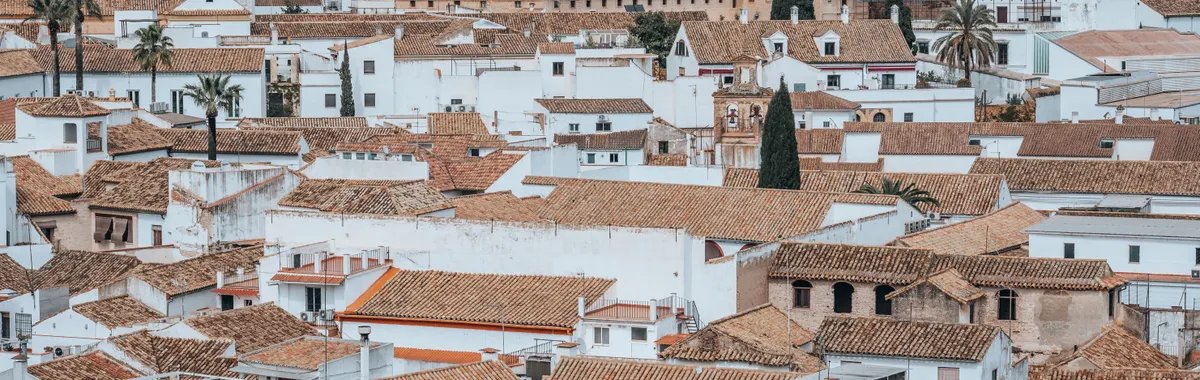 Aerial shot of Córdoba's traditional white rooftops and Mezquita, showcasing historic architecture.