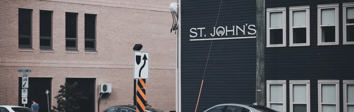 City street view featuring St. John's sign, cars, and urban architecture.