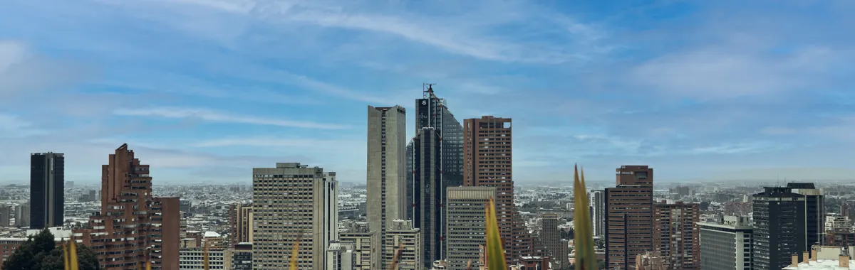 A picturesque view of Bogotá's skyline featuring modern skyscrapers against a bright blue sky.