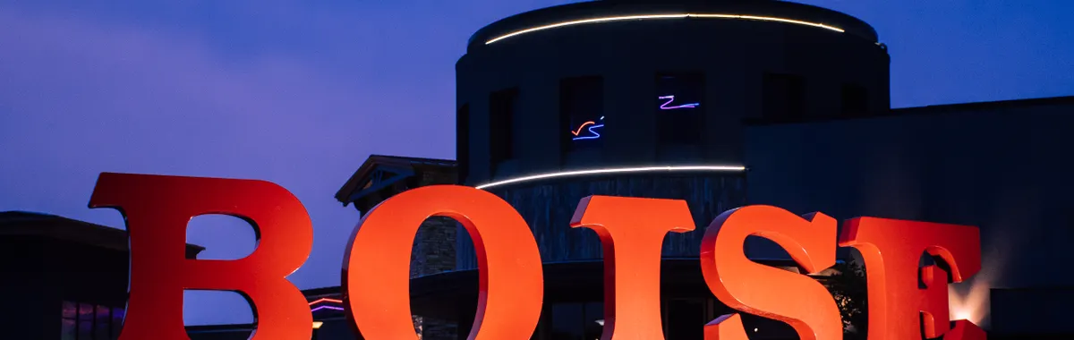 Large red 'Boise' sign against a modern building at twilight.