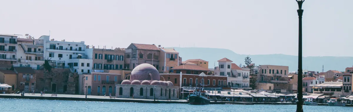 Beautiful waterfront view of Chania with historic architecture and blue sea.