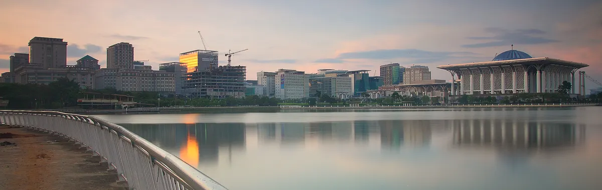 Captivating cityscape of Putrajaya at sunset with reflective waterfront view.