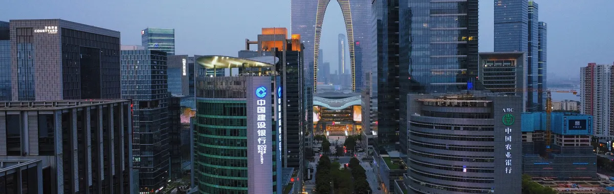 Stunning modern architecture of Suzhou's Gate to the East at dusk, showcasing a vibrant financial district.
