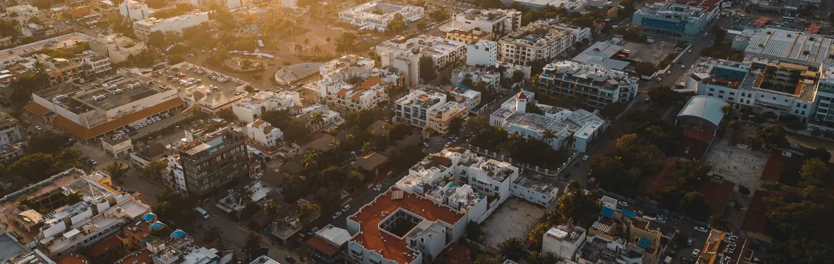 Stunning aerial cityscape of Playa del Carmen, Mexico at sunset, capturing urban life and architecture.