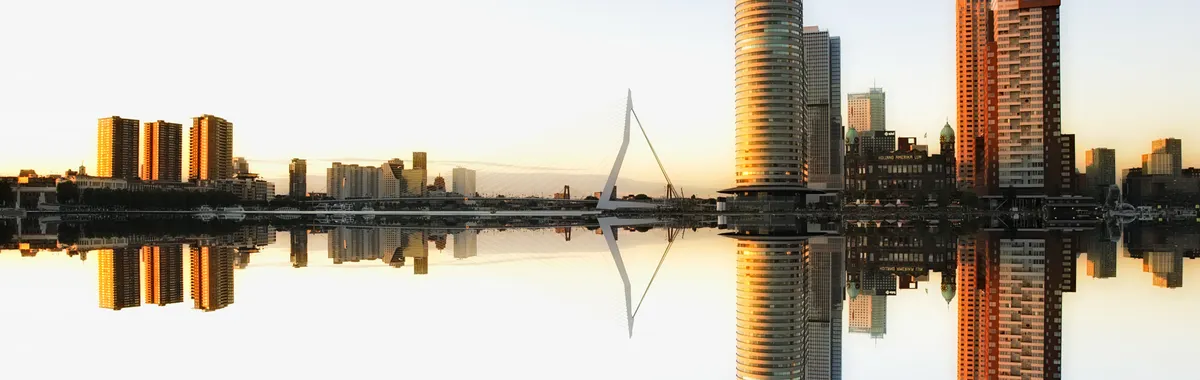 Captivating view of Rotterdam skyline reflecting in water at dusk, showcasing modern architecture.
