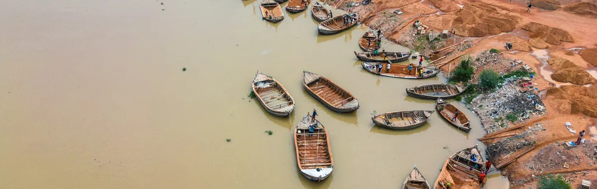 ניז׳ר: Aerial view of wooden boats along the Niger River in Bamako, Mali. Busy riverbank activity.