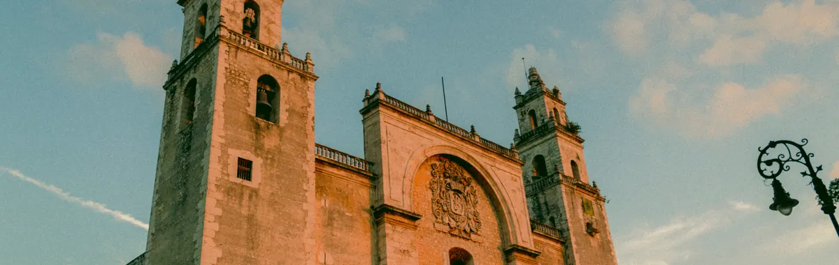 The grand facade of Mérida's iconic cathedral bathed in warm sunset light.