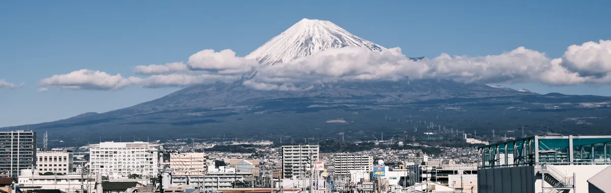A breathtaking view of Mount Fuji towering over the cityscape of Shizuoka, Japan.