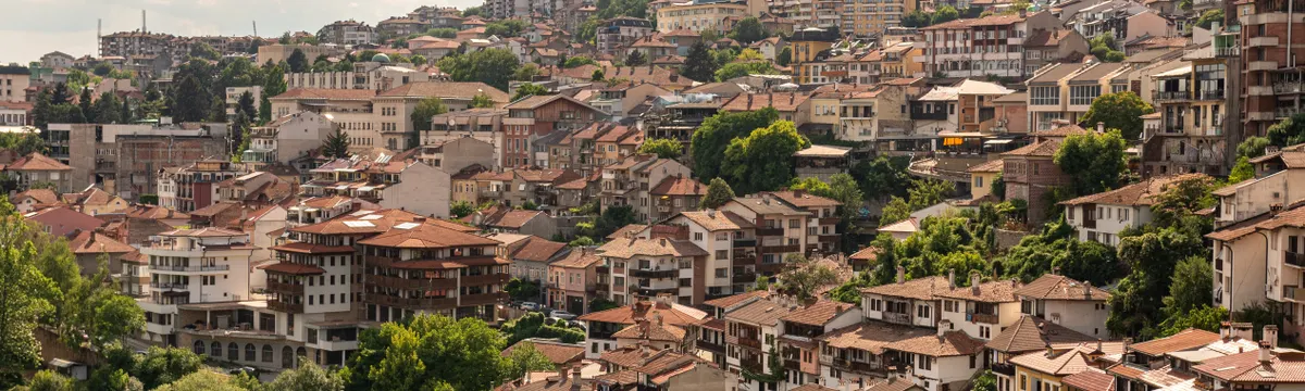 בולגריה: A picturesque aerial view of Veliko Tarnovo, Bulgaria, showcasing its unique architecture and lush greenery.