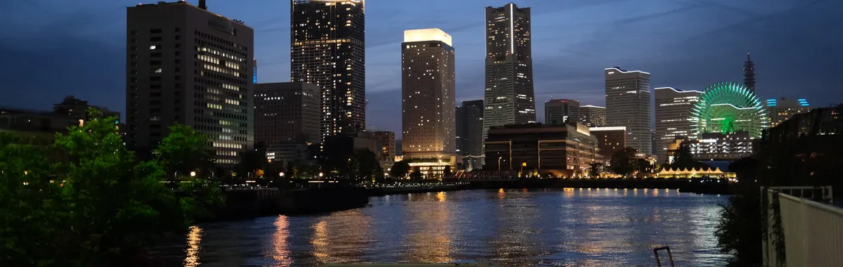 Beautiful view of Yokohama city lights reflecting on the water during twilight.