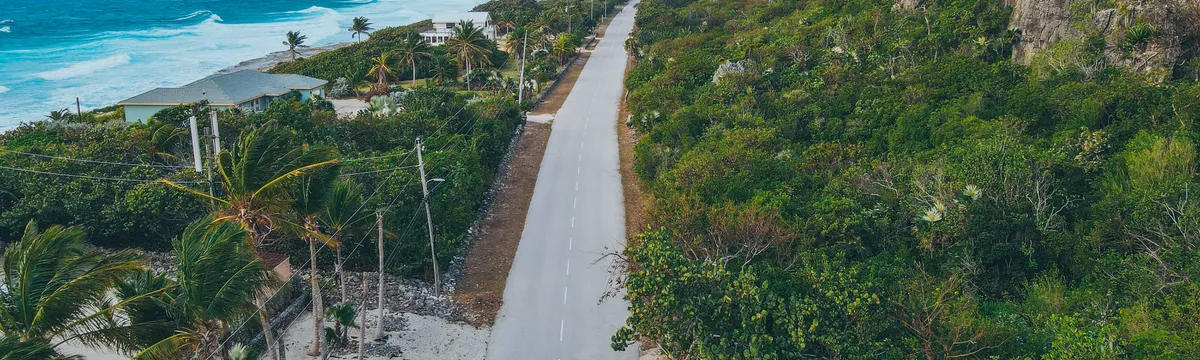 איי קיימן: Aerial view showcasing the stunning coastline and road beside cliffs in Cayman Islands.