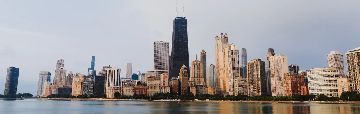Stunning view of Chicago's skyline with calm waterfront reflections under a clear sky.