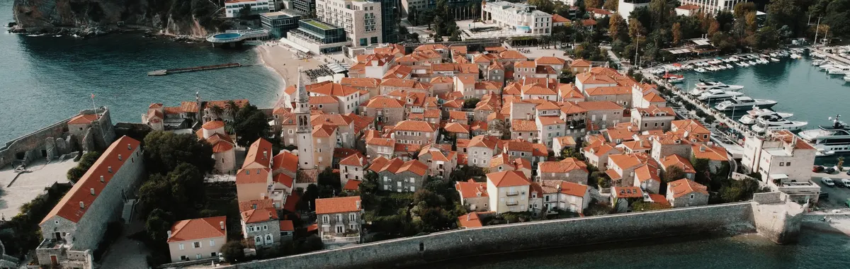 Stunning aerial view of Budva Old Town with red-tiled roofs by the sea.