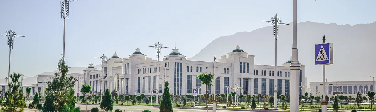 טורקמניסטן: Elegant white government building with ornate lamp posts in Ashgabat.