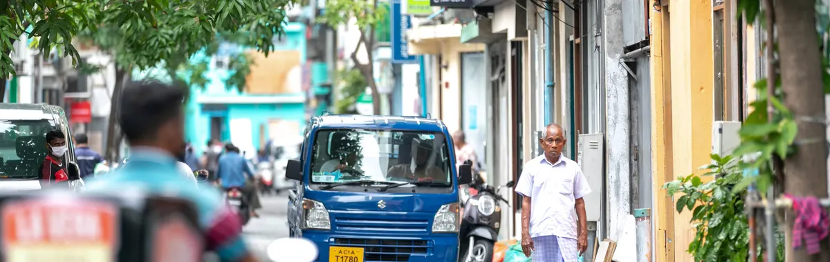 A bustling street in Malé, Maldives, featuring a variety of daily life activities and local architecture.