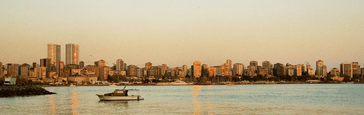 A serene view of the Beirut skyline with a boat on calm waters during sunset.