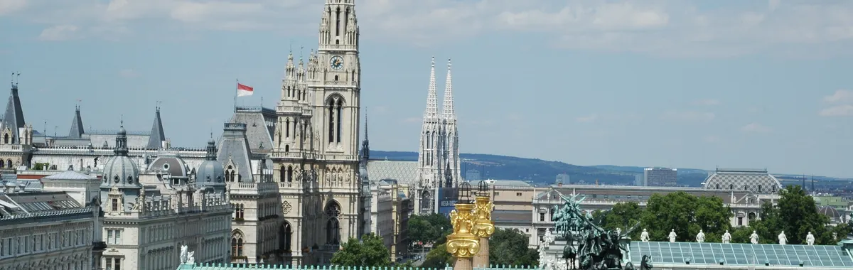 Aerial view of Vienna showcasing the town hall, Votivkirche, and architectural landmarks.