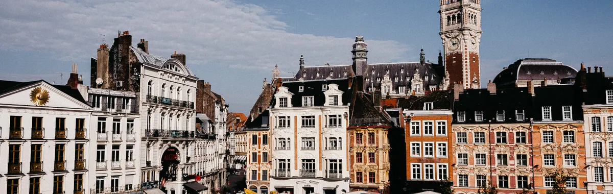 Scenic view of colorful buildings at Lille Grand Place with clear blue sky in daylight.