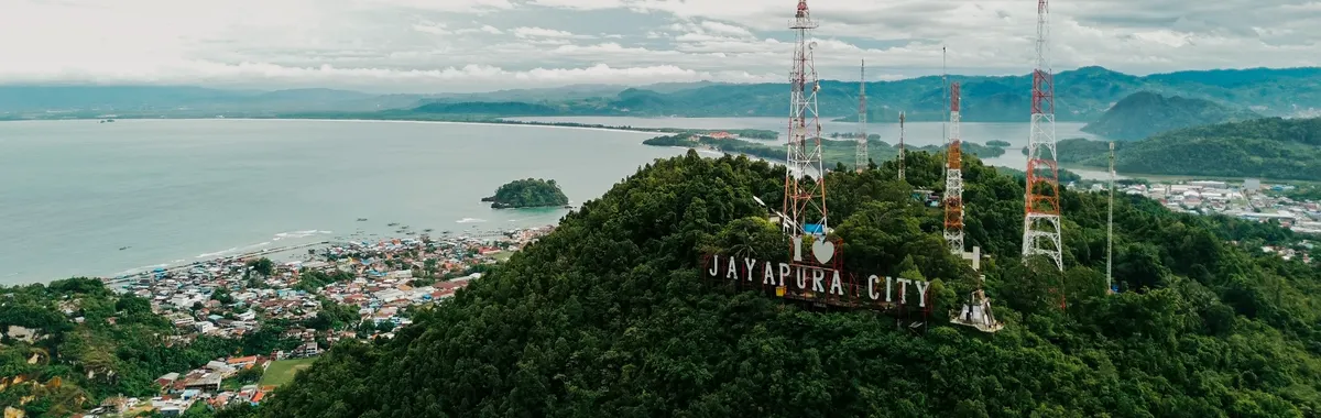 Stunning aerial view of Jayapura City with lush hills and ocean in Papua, Indonesia.