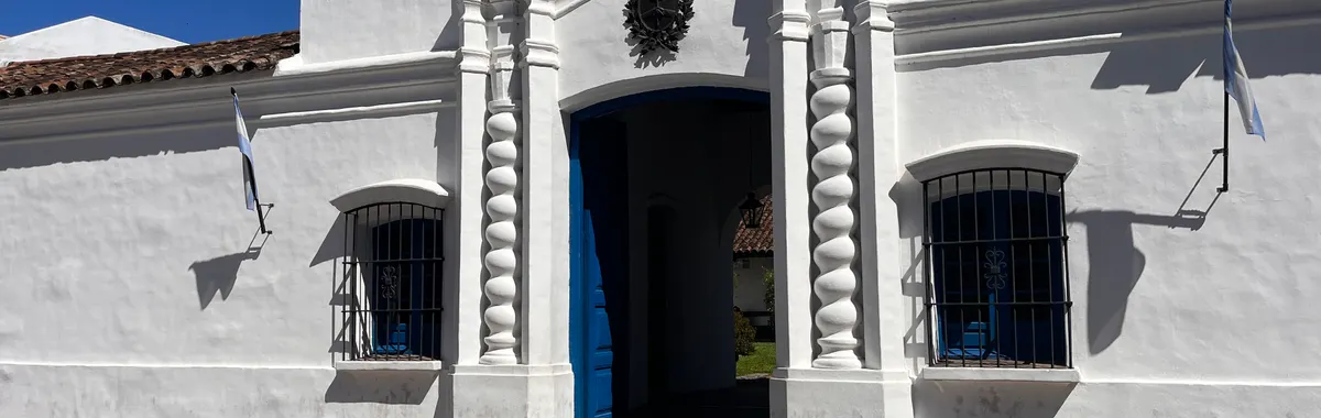 Front view of the historic Casa de Tucumán under clear blue skies in San Miguel de Tucumán, Argentina.