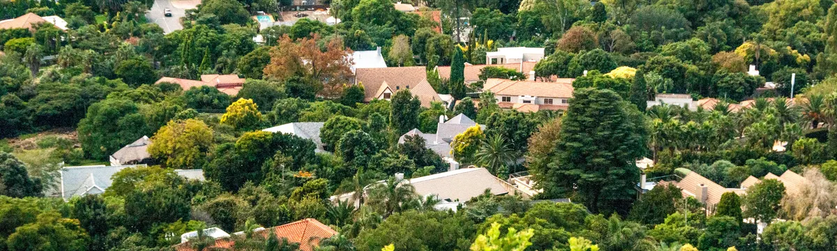 דרום אפריקה: A lush aerial view of a suburban neighborhood surrounded by greenery in South Africa.