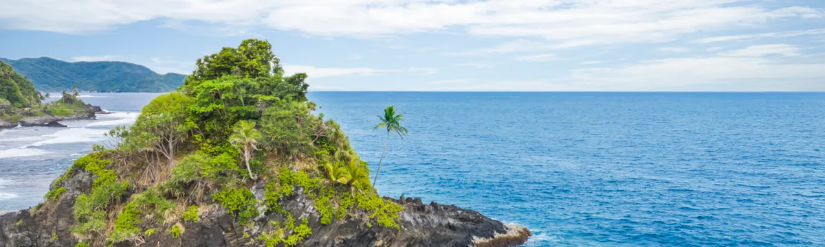 סמואה: Explore the stunning Alega Beach with vibrant turquoise waters and lush greenery in American Samoa.