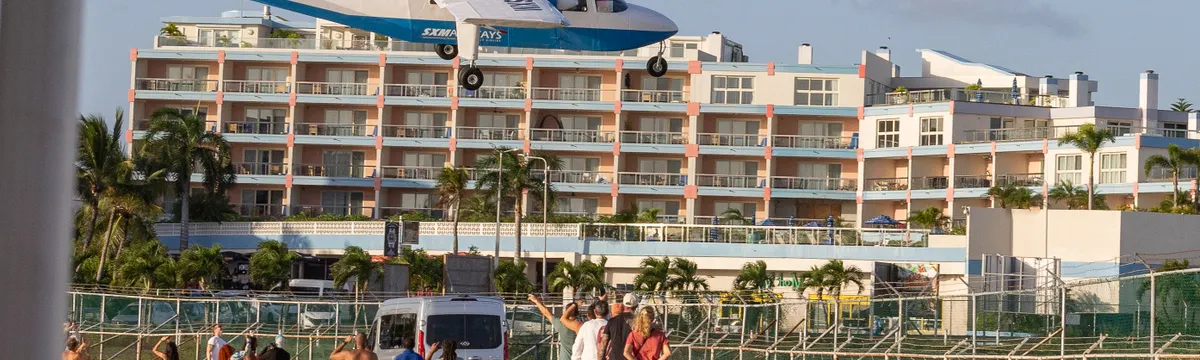 סנט מארטן: A plane flies low over tourists at Maho Beach, Sint Maarten, near the airport.