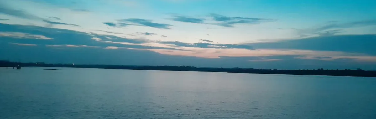 Peaceful view of Ambazari Lake at sunset with blue and pink skies reflecting on water in Nagpur, India.