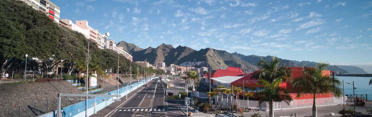 Explore the vibrant cityscape of Santa Cruz de Tenerife featuring colorful architecture and scenic mountains.