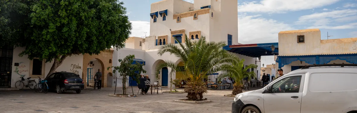 Quaint street scene in Djerba, Tunisia showcasing traditional architecture and daily life.