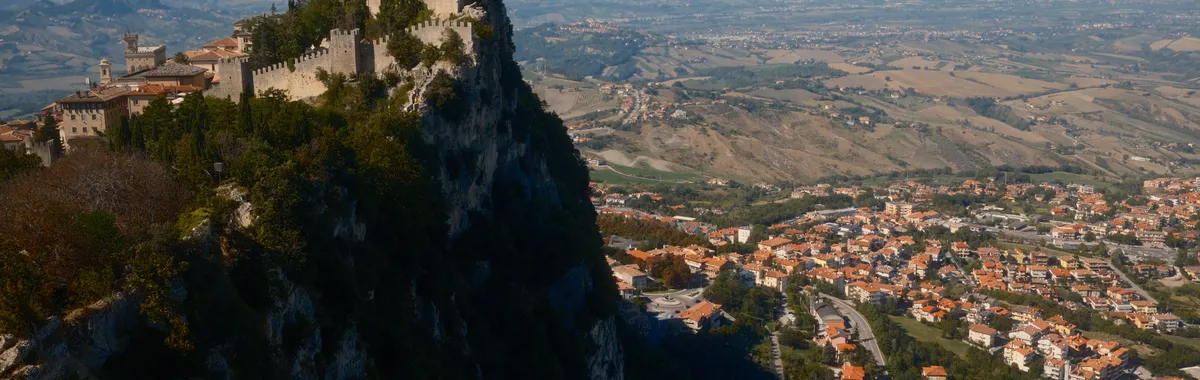 Discover San Marino's historic fortress perched dramatically atop Mount Titano overlooking the scenic landscape.