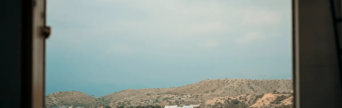 Framed view of Tadjoura coastline seen from a ship window, Djibouti's serene landscape.