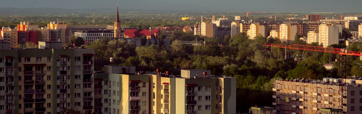 Aerial view of Wrocław showcasing urban architecture and a serene sunset backdrop.