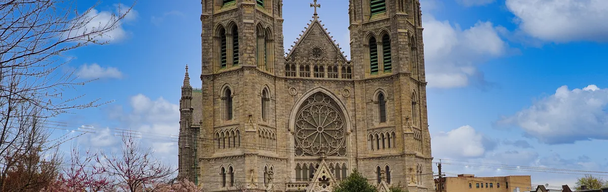 Beautiful frontal view of Cathedral Basilica of the Sacred Heart surrounded by blossoming trees in Newark, New Jersey.