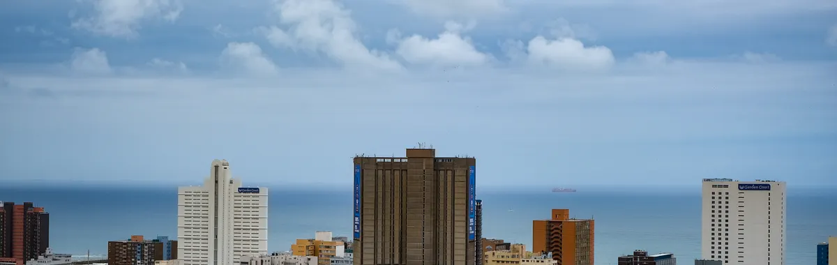 Aerial view of Durban's modern cityscape against the Indian Ocean with high-rise buildings.