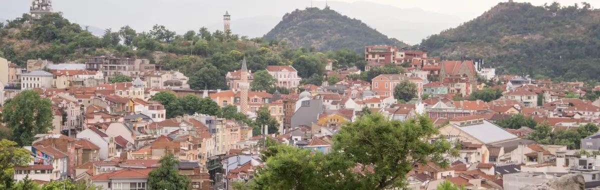 Explore the charming architecture and historic sites of Plovdiv's old town with hills in the backdrop.