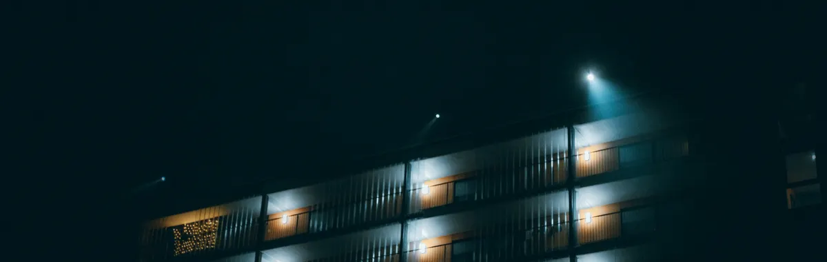 Night view of a modern building facade illuminated by soft lighting in Breda, Netherlands.