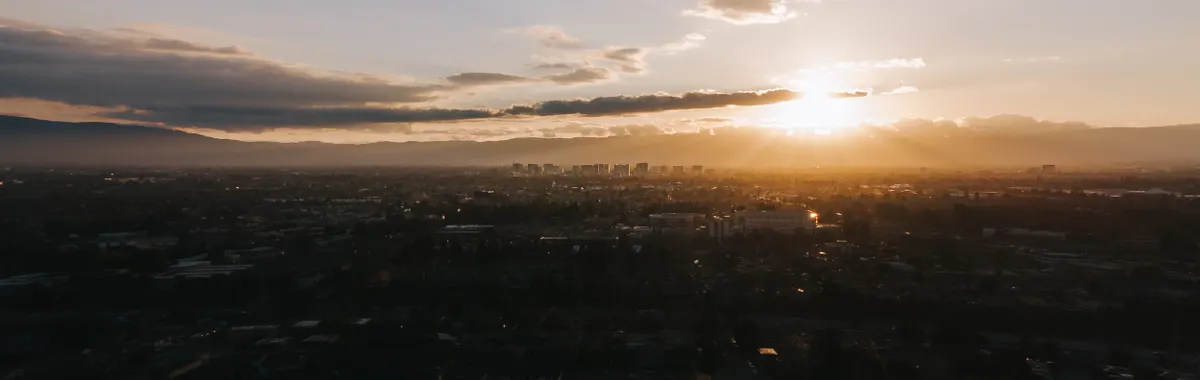 Dramatic aerial sunset view over San Jose showcasing urban skyline and golden skies.