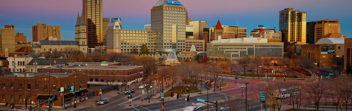 Beautiful dusk view of Saint Paul's skyline with vibrant city lights and traffic.