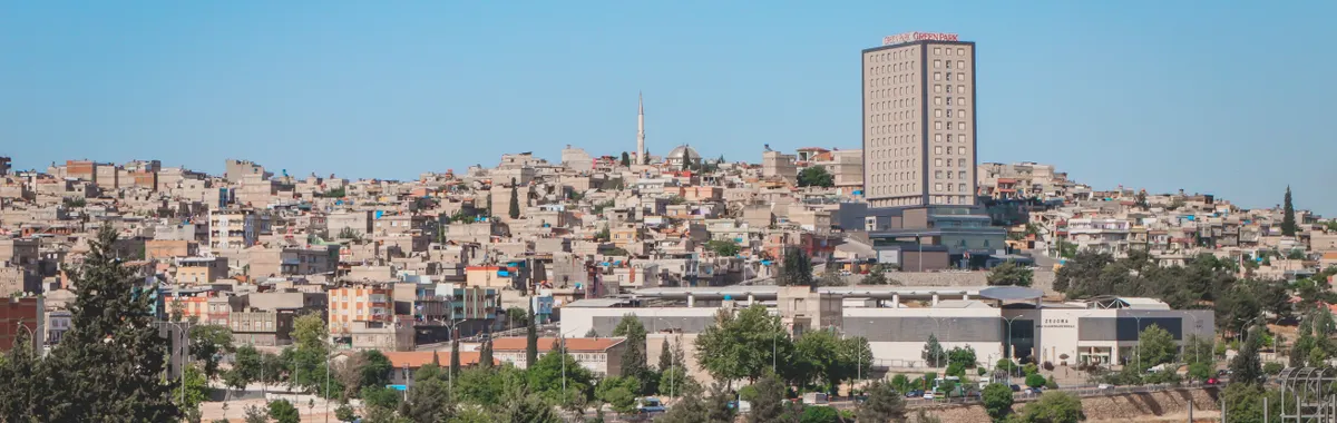 View of Gaziantep cityscape featuring distinctive architecture under a bright blue sky.