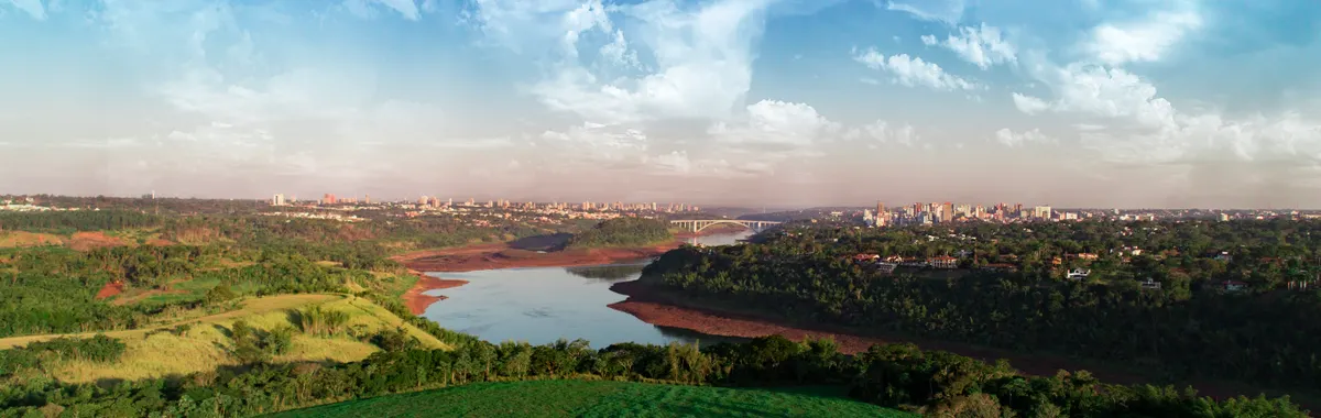A breathtaking view of the river and landscape in Foz do Iguaçu, Brazil, under a vibrant sky.